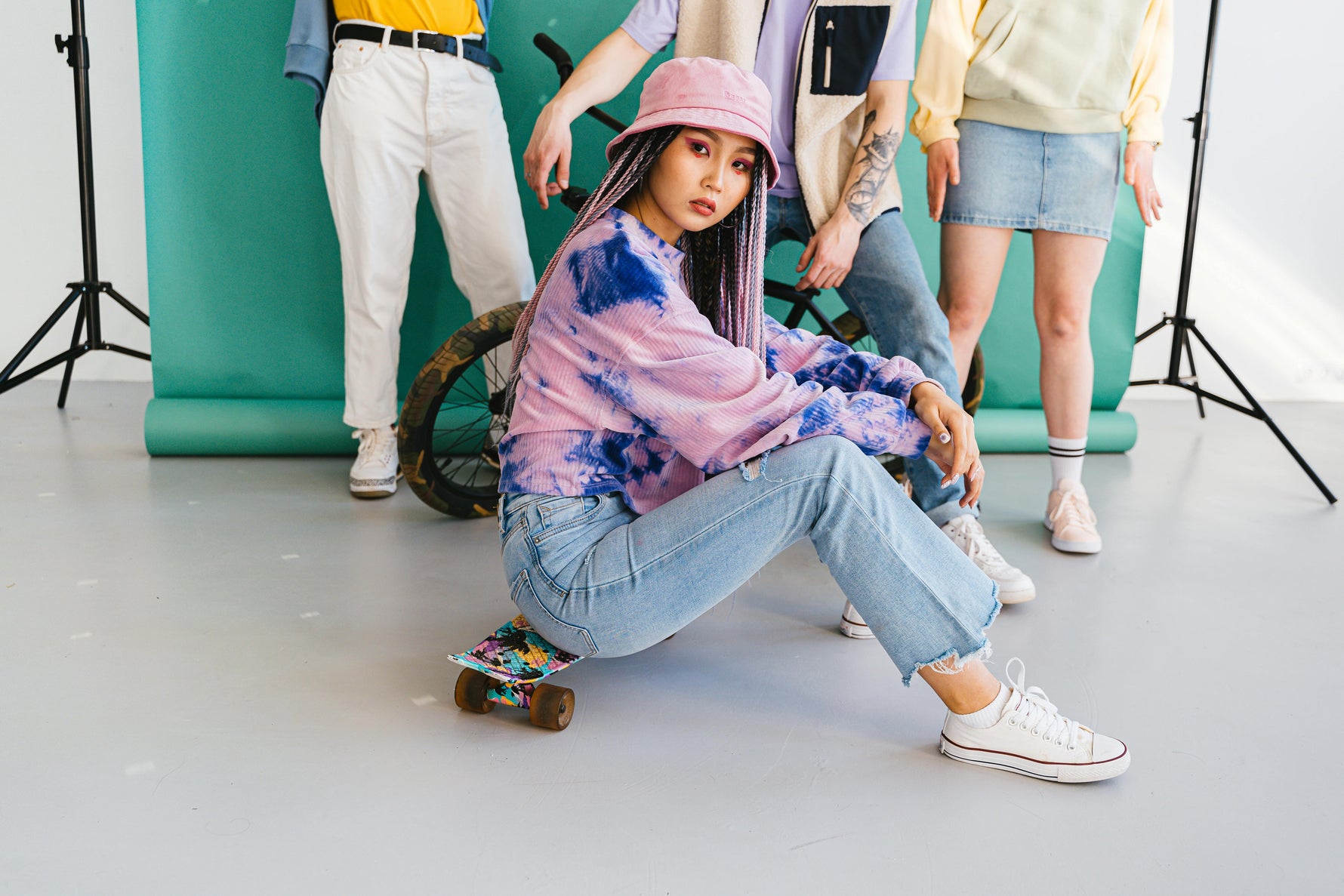 An urban street scene with a group of young adults wearing limited edition streetwear (oversized tees, sneakers)